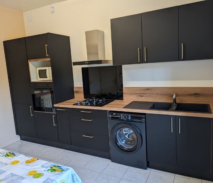 Rénovation de cuisine à Athies avec meubles noirs et plan de travail bois